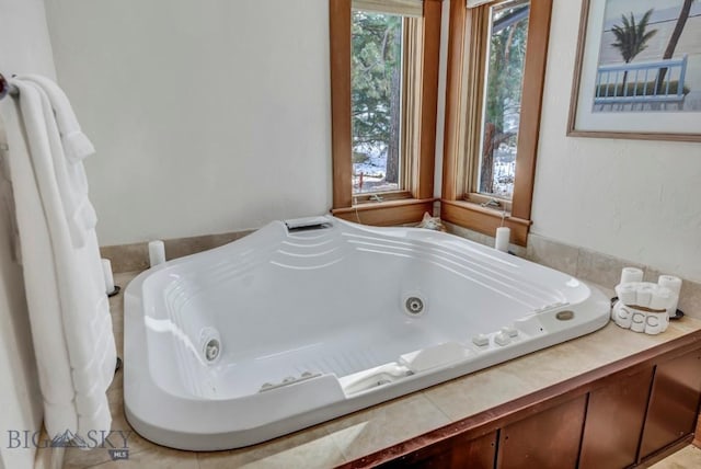 bathroom featuring a whirlpool tub and a wealth of natural light