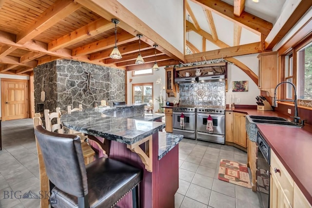 kitchen featuring a breakfast bar area, range with two ovens, light tile patterned flooring, vaulted ceiling with beams, and a sink