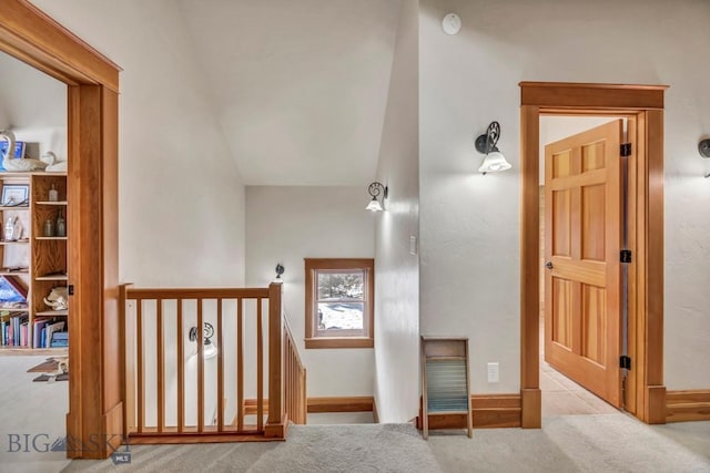 corridor featuring an upstairs landing, carpet flooring, and baseboards