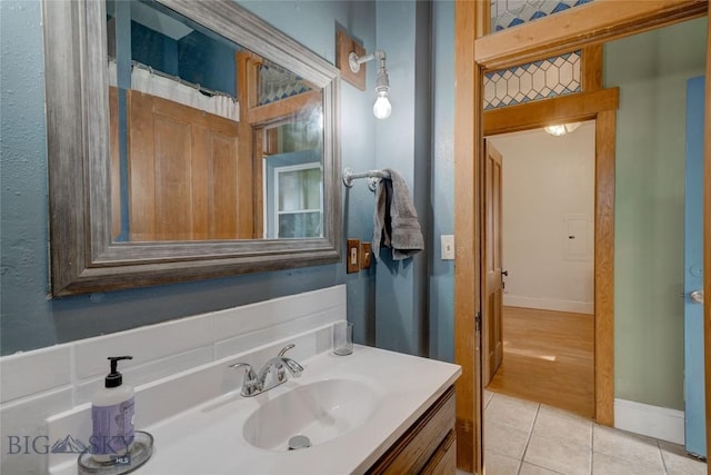 bathroom with tile patterned flooring, vanity, and baseboards