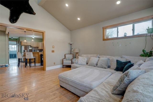 living room with recessed lighting, baseboards, light wood-style floors, and high vaulted ceiling