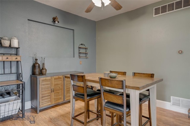 dining area featuring visible vents, baseboards, light wood-style floors, and a ceiling fan