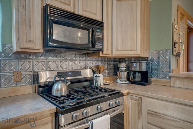 kitchen featuring light brown cabinets, black microwave, gas range, light countertops, and decorative backsplash