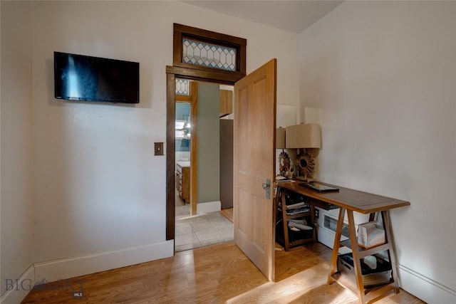 corridor with baseboards and light wood-type flooring