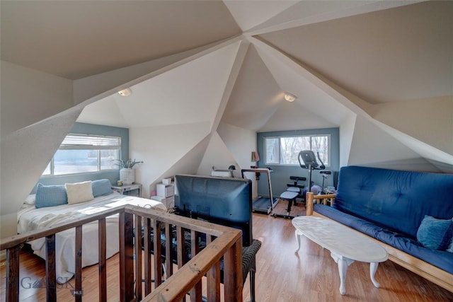 bedroom with lofted ceiling and wood finished floors