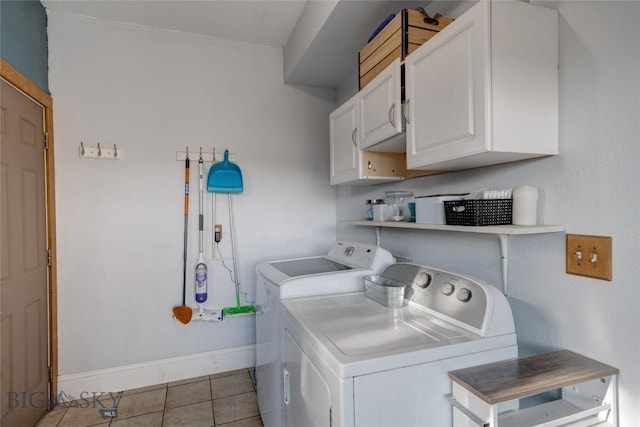 washroom with light tile patterned floors, cabinet space, washer and dryer, and baseboards