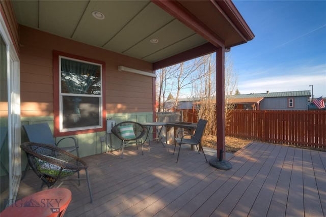 deck with outdoor dining area and fence