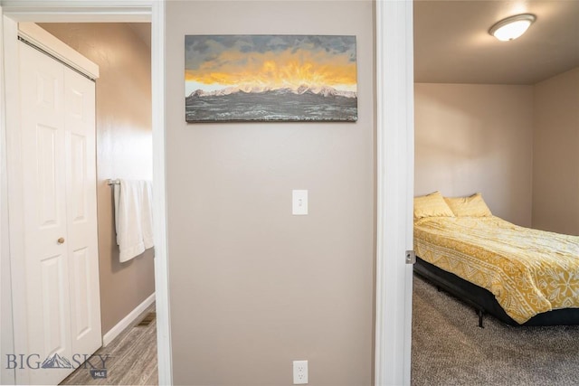 carpeted bedroom with baseboards and a closet