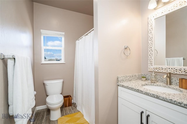 full bathroom with vanity, toilet, wood finished floors, and baseboards