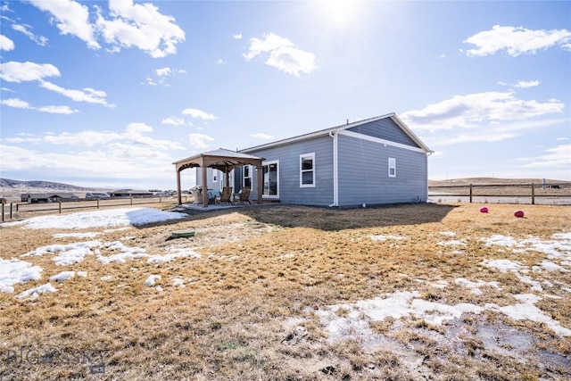 back of house with a detached carport, a gazebo, and fence