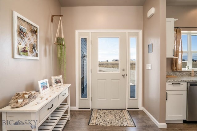 foyer featuring dark wood-type flooring and baseboards