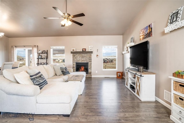 living room featuring baseboards, visible vents, a fireplace, dark wood-style flooring, and ceiling fan