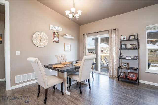 dining room with baseboards, visible vents, dark wood finished floors, vaulted ceiling, and a notable chandelier