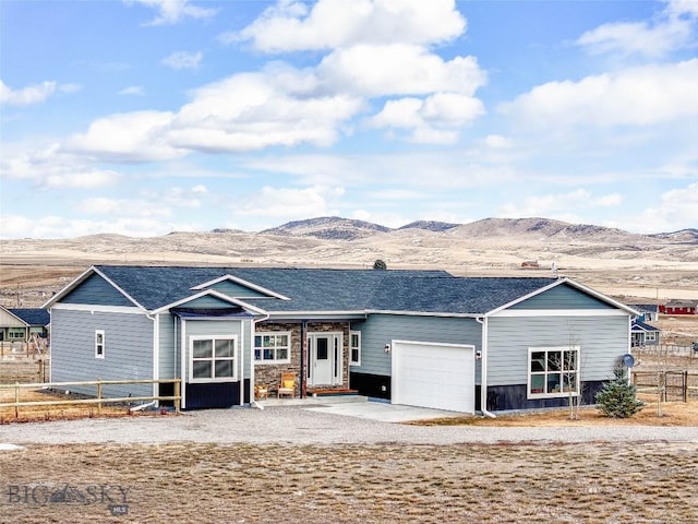 view of front of property featuring a garage, a shingled roof, a mountain view, and fence