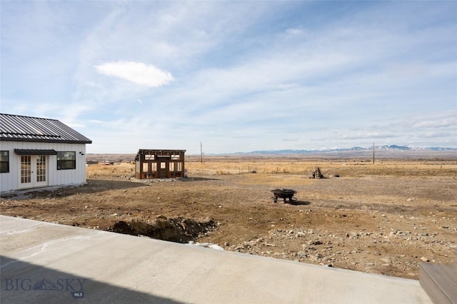 view of yard featuring a rural view and french doors