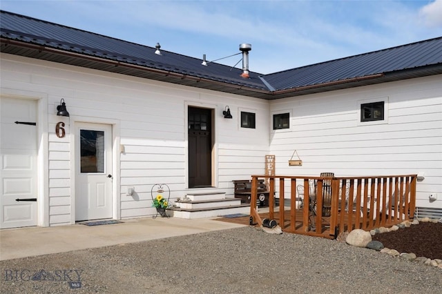 back of house featuring metal roof and a garage