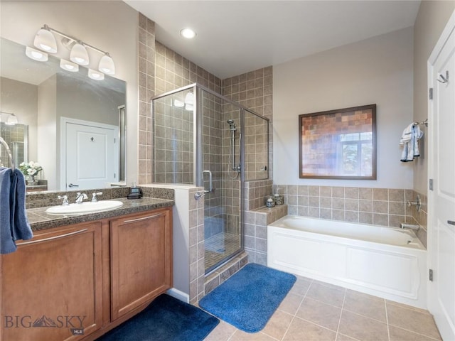 bathroom featuring a garden tub, a stall shower, vanity, and tile patterned flooring