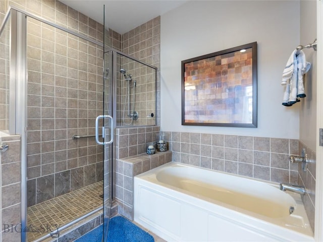 bathroom featuring a bath and a stall shower