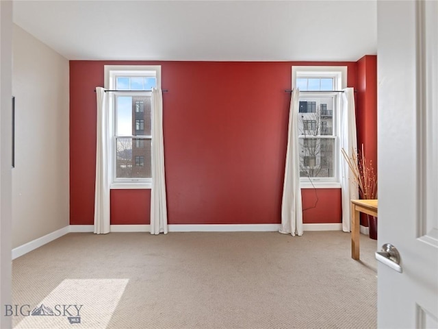 unfurnished room with carpet flooring, a healthy amount of sunlight, and baseboards