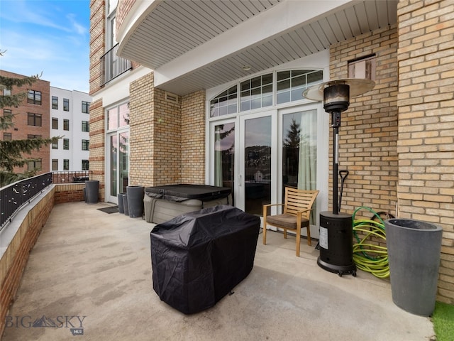 view of patio / terrace featuring french doors, a balcony, and a hot tub