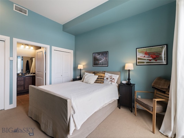 bedroom with light carpet, visible vents, connected bathroom, and a closet