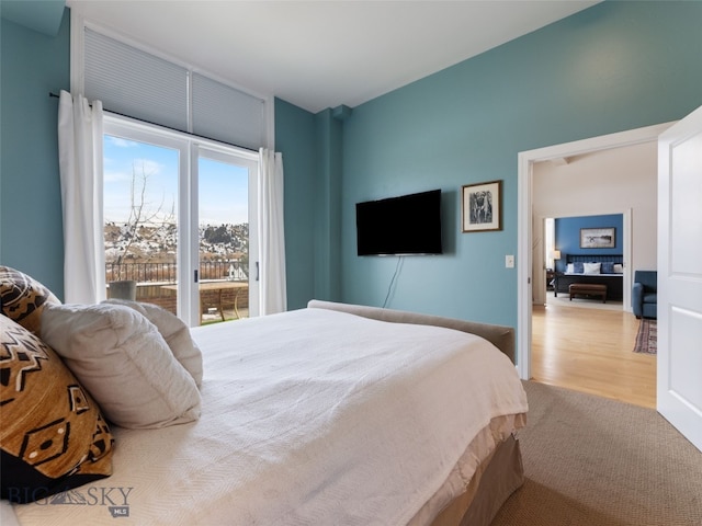 bedroom featuring access to exterior and wood finished floors