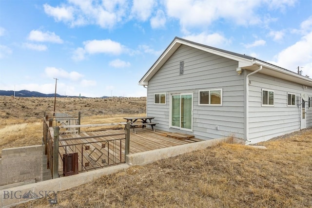 back of property featuring a deck with mountain view