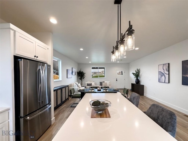 dining space featuring recessed lighting, light wood-type flooring, and baseboards