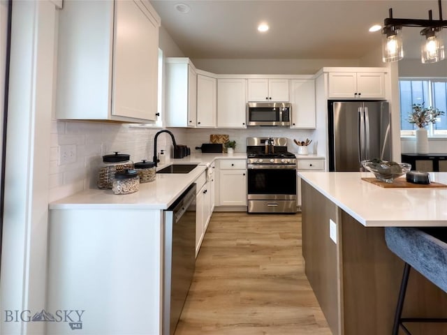 kitchen featuring a sink, light countertops, backsplash, and stainless steel appliances