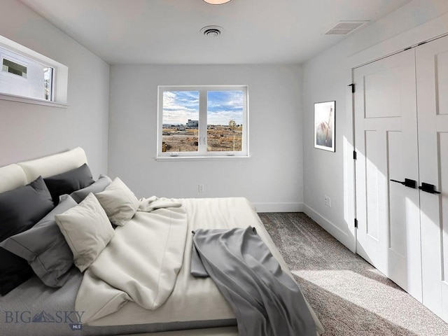 carpeted bedroom featuring baseboards and visible vents