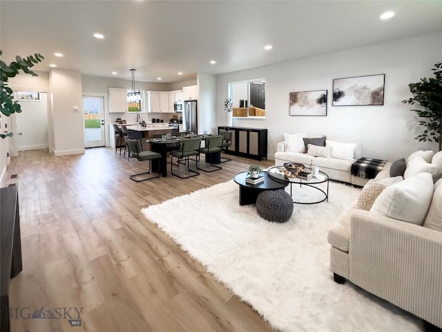 living room with recessed lighting, light wood-type flooring, and baseboards