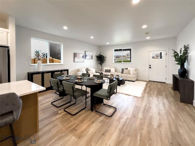 dining room with recessed lighting, baseboards, and light wood-style flooring