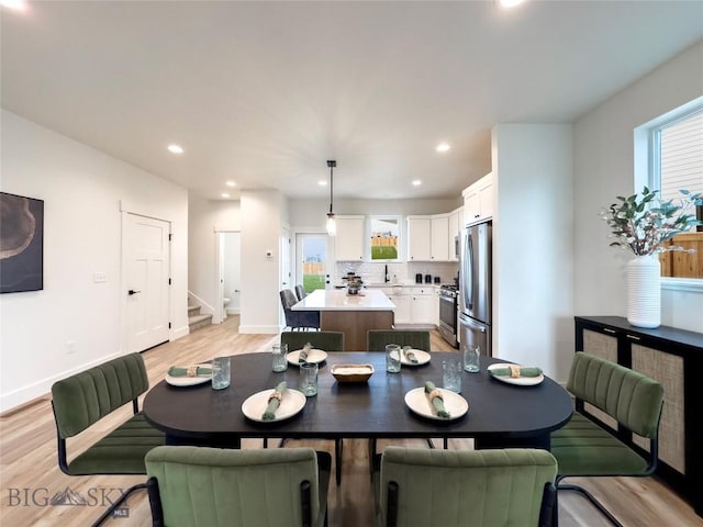 dining room with recessed lighting, stairway, light wood-style flooring, and baseboards