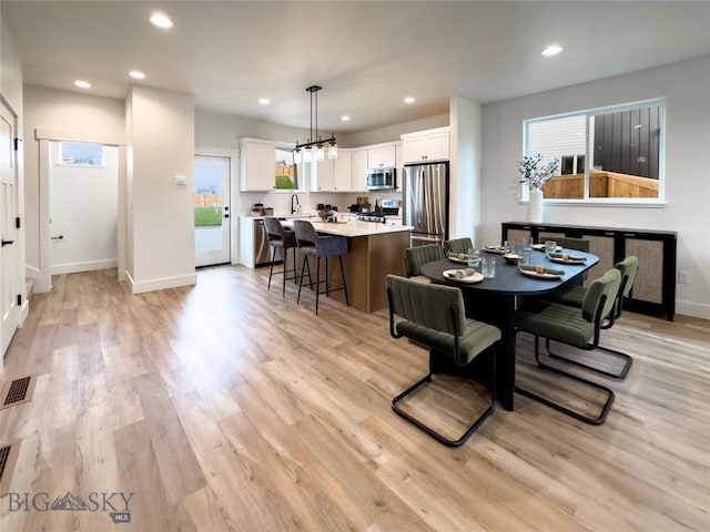 dining area featuring recessed lighting, light wood-style flooring, and baseboards