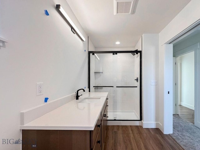 bathroom with visible vents, a stall shower, vanity, and wood finished floors