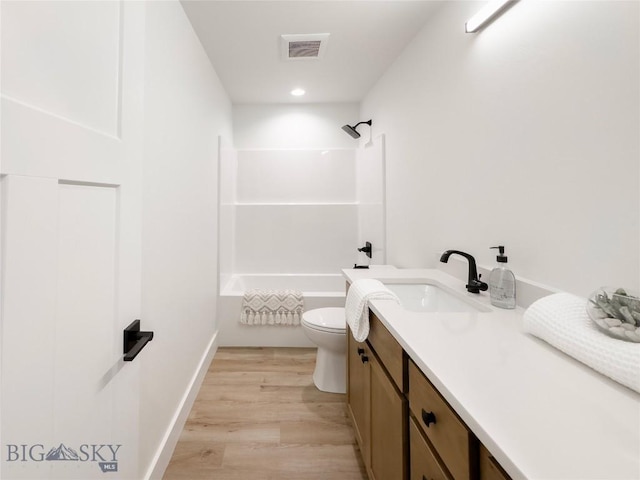 full bathroom featuring vanity, wood finished floors, visible vents, bathing tub / shower combination, and toilet