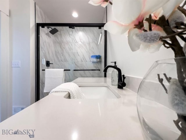 full bath with a sink, visible vents, recessed lighting, and a shower stall