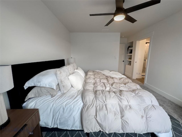 carpeted bedroom with connected bathroom, baseboards, and a ceiling fan