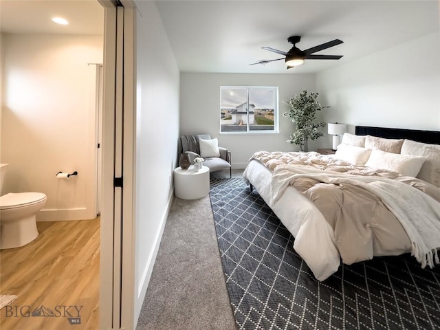 bedroom with connected bathroom, a ceiling fan, baseboards, and wood finished floors