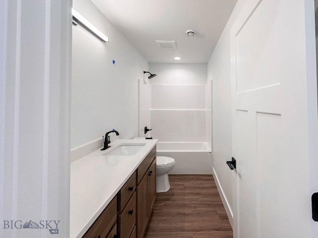 full bathroom featuring vanity, wood finished floors, visible vents, shower / tub combination, and toilet