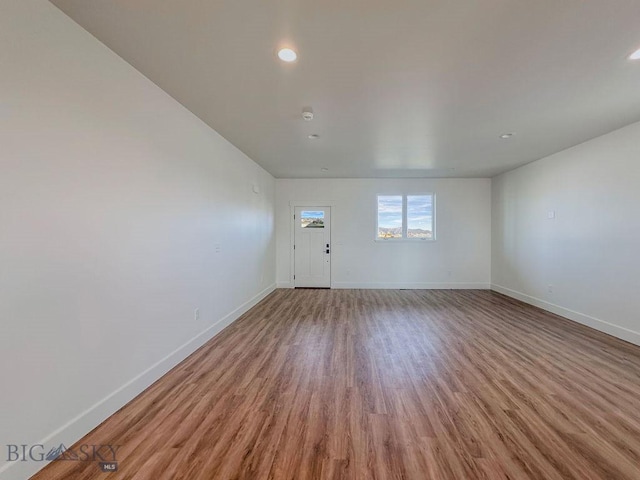 unfurnished room with recessed lighting, wood finished floors, and baseboards