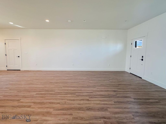 empty room with recessed lighting, baseboards, and wood finished floors