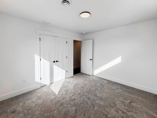 unfurnished bedroom featuring a closet, baseboards, visible vents, and carpet floors