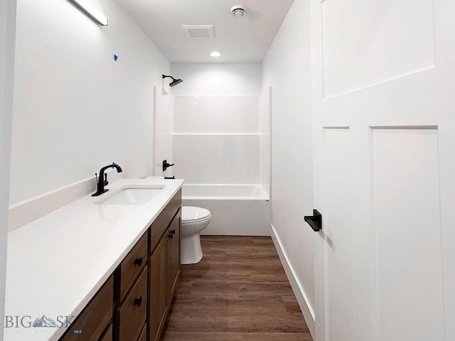 full bathroom with vanity, wood finished floors, visible vents, tub / shower combination, and toilet