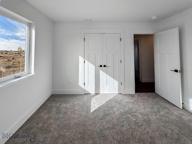 unfurnished bedroom featuring a closet, carpet flooring, baseboards, and visible vents