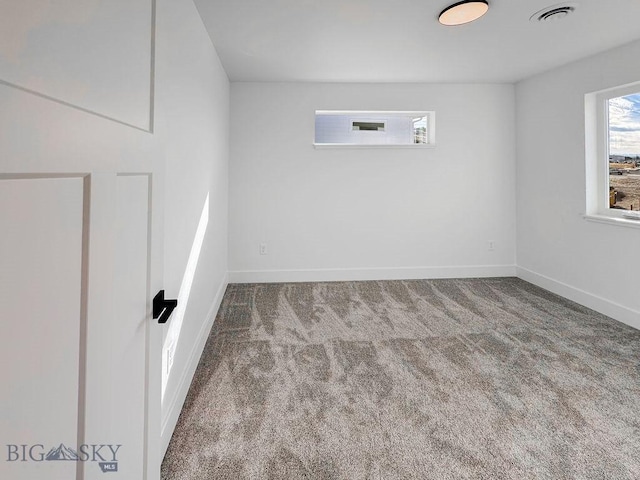 carpeted empty room featuring visible vents and baseboards