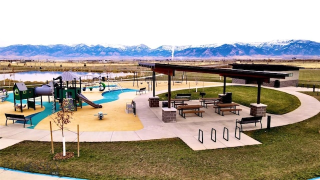 exterior space with a mountain view, playground community, and a yard