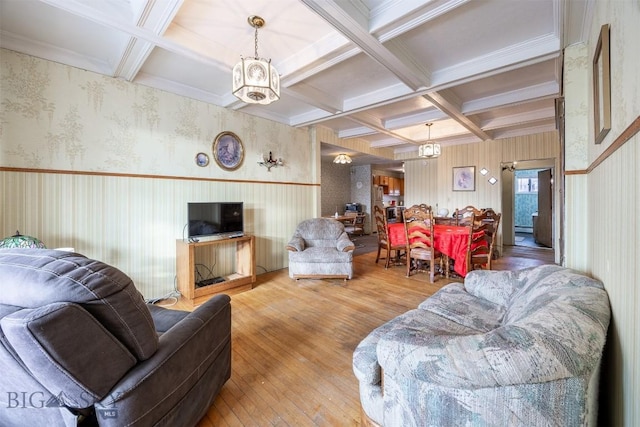 living area with beamed ceiling, coffered ceiling, hardwood / wood-style floors, crown molding, and wallpapered walls