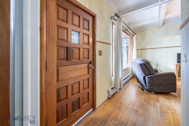 entrance foyer featuring a wainscoted wall, light wood finished floors, coffered ceiling, wallpapered walls, and beam ceiling