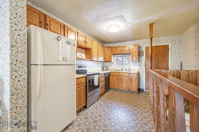 kitchen featuring wallpapered walls, light countertops, black dishwasher, stainless steel range with electric cooktop, and freestanding refrigerator